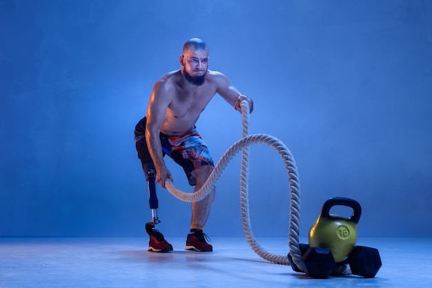 Athlete with disabilities or amputee isolated on blue studio wall