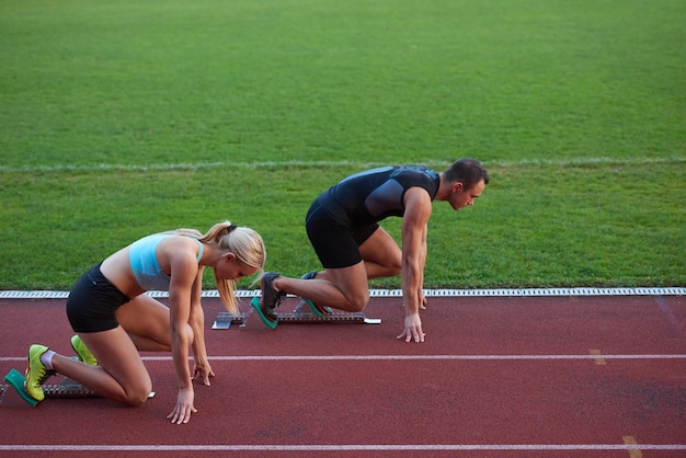 athlete woman group  running on athletics race track on soccer stadium and representing competition and leadership concept in sport