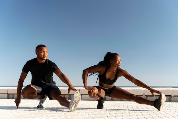 Athlete woman man doing yoga and stretching body on summer island beach