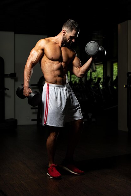 Athlete Working Out Biceps In A Gym  Dumbbell Concentration Curls