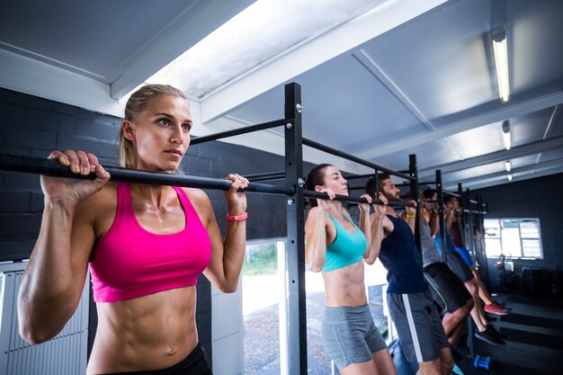 Athletes doing chin-ups in gym