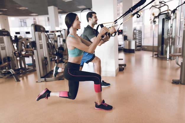 Athletes do exercises in a modern gym with modern simulators