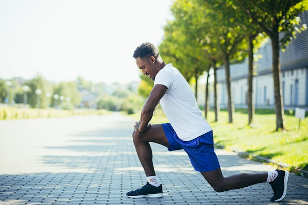 Uomo afroamericano atletico che fa allenamenti mattutini, stretching e fitness