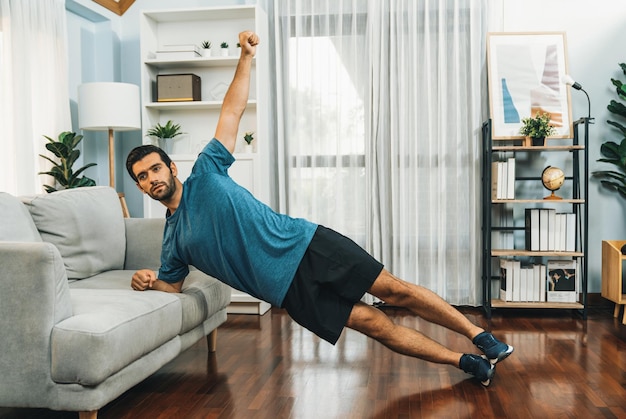 Athletic body and active sporty man using furniture for effective targeting muscle gain exercise at gaiety home exercise as concept of healthy fit body home workout lifestyle