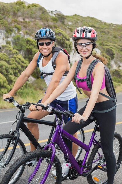 Photo athletic couple mountain biking