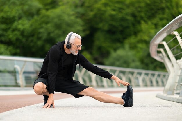 Athletic elderly man have workout outdoors stretching body