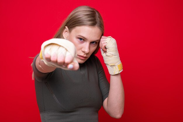 Athletic female boxer on red background