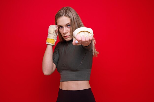 Athletic female boxer on red background