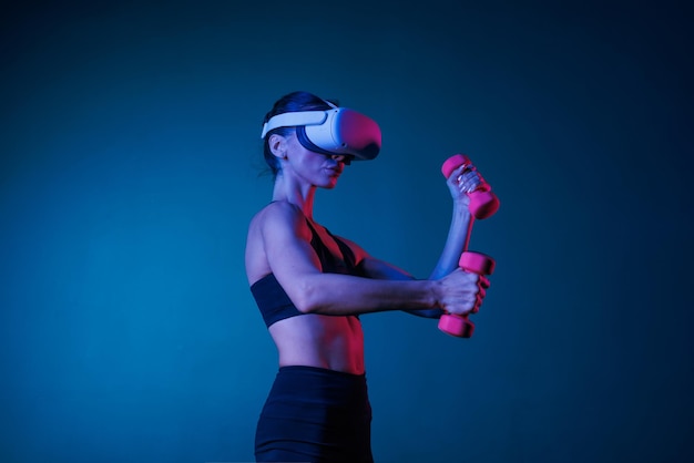 Фото Спортивная девушка занимается спортом онлайн в vr-очках на темном фоне онлайн спортивная тренировка