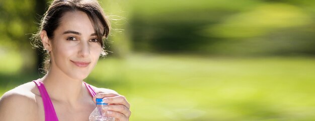 Photo athletic girl drinking water after exercising