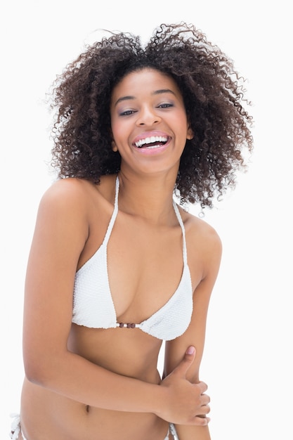Athletic girl in white bikini smiling at camera
