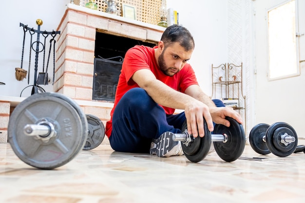 Athletic guy addding more weights to the dumbell