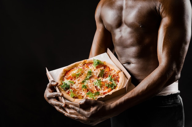 Athletic handsome naked body of black man works in pizza delivery