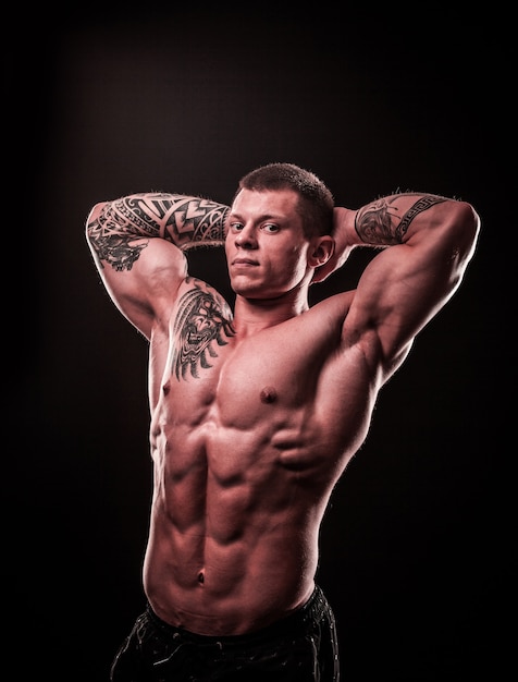 Photo athletic male bodybuilder holding hands behind head . photo with copy space