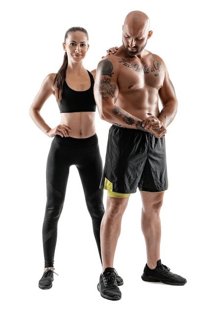 Photo athletic man in black shorts and sneakers with brunette woman in leggings and top posing isolated on