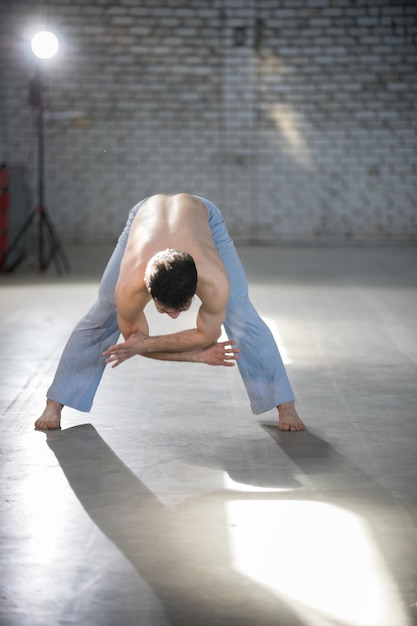 An athletic man on capoeira training bending down