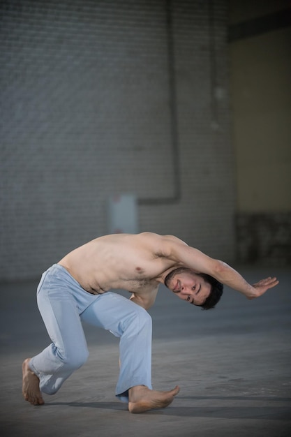 An athletic man on capoeira training standing in the pose