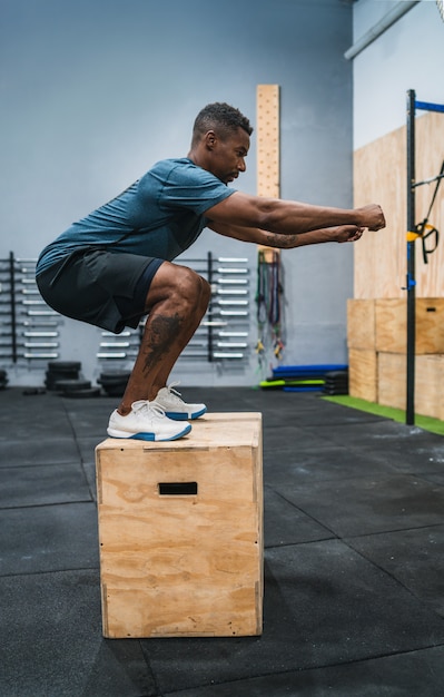 Athletic man doing box jump exercise.