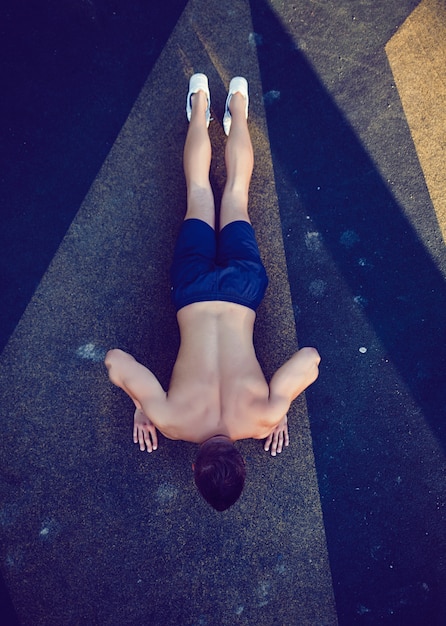 Athletic man doing push ups outdoor