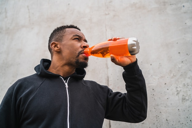 Athletic man drinking something after training.