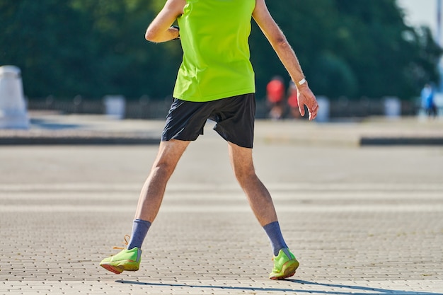 Athletic man jogging in sportswear on city road