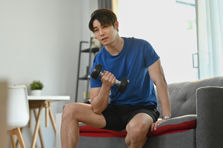 Photo 아침 운동 동안 소파에 아령을 드는 운동 남자 건강한 라이프 스타일과 피트니스 개념