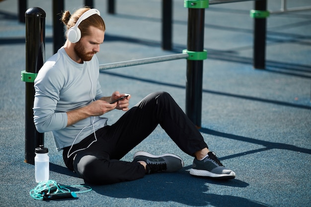 Athletic man resting on training ground