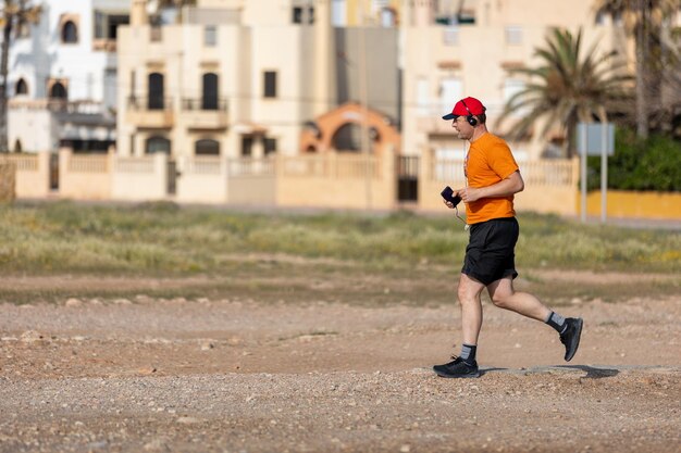 Athletic man running in park with headphones on sunny summer day Healthy lifestyle Active adult men is jogging