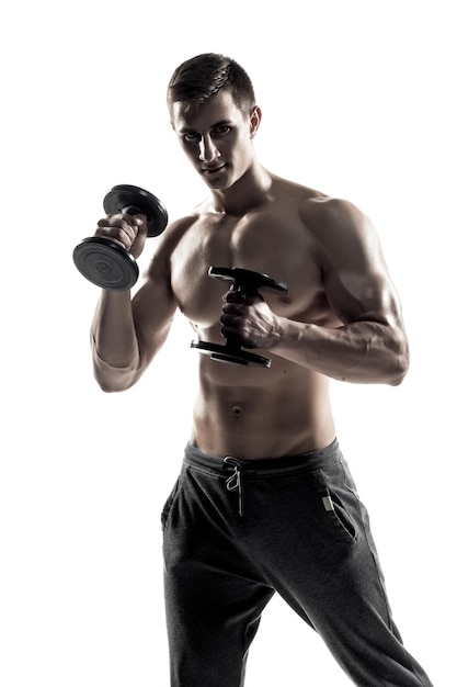 Athletic man showing muscular body and doing exercises with dumbbells