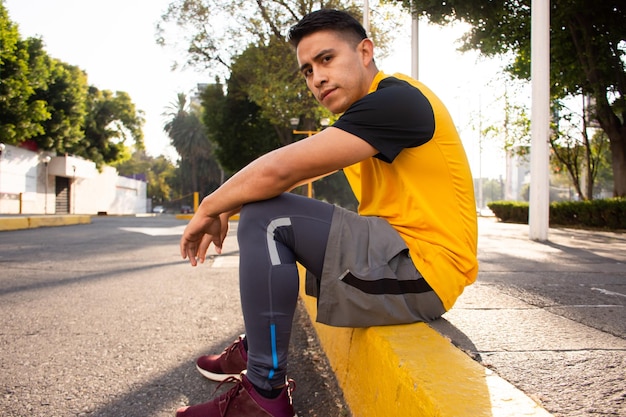 Athletic man sitting on the street in the morning