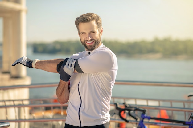 Athletic man in sportswear stretching out on street