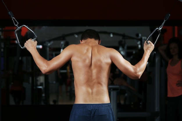 Photo athletic man training back muscles in gym