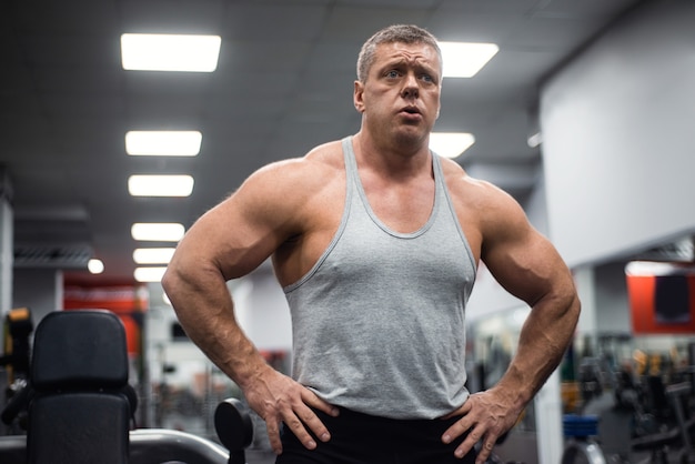 Athletic man trains in the gym. 