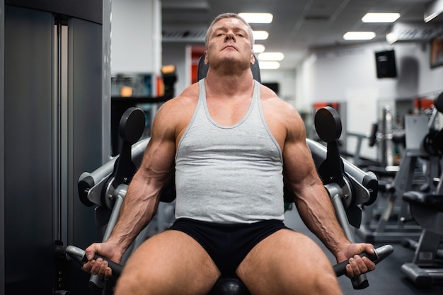 Athletic man trains in the gym.