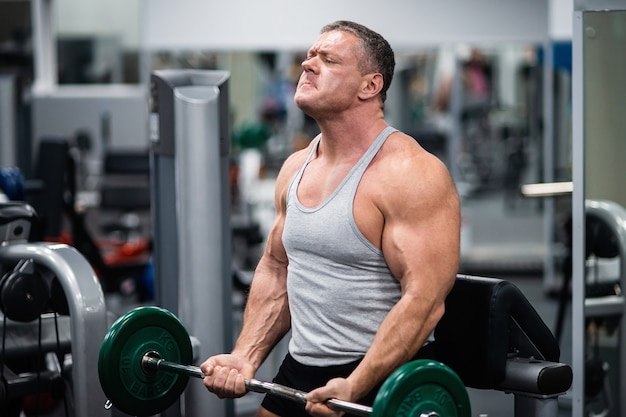 Athletic man trains in the gym.