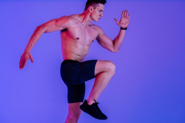 Athletic man with fit muscular body training in studio