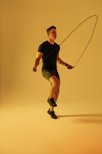 Athletic man with fit muscular body training in studio