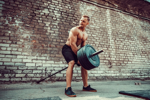 バーベルでワークアウト運動の男。強さと動機。背中の筋肉の運動