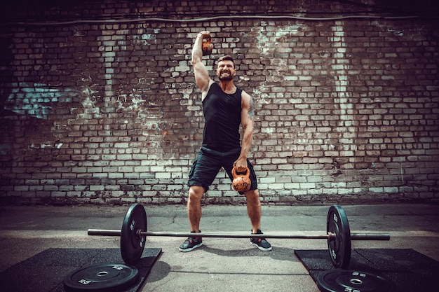 Foto uomo atletico che risolve con un kettlebell. forza e motivazione