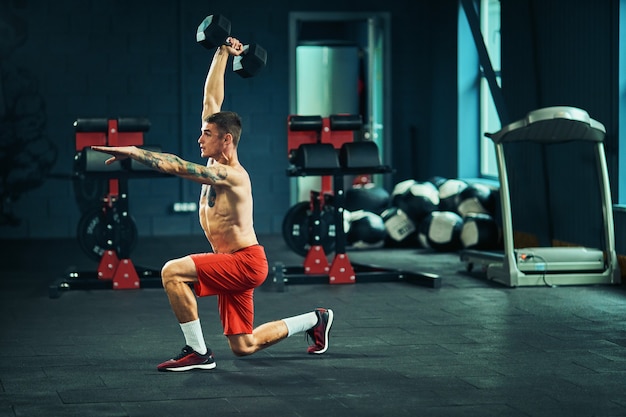 Athletic man works out at the gym with a barbell