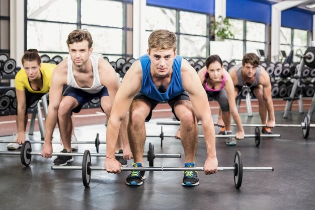 Athletic men and women working out at crossfit gym