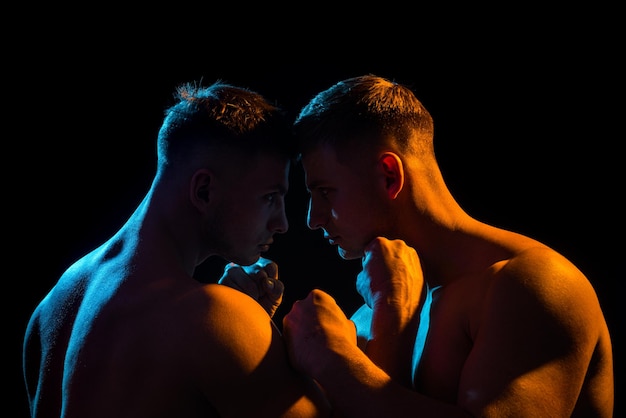 Athletic muscular man body fighting on a black background