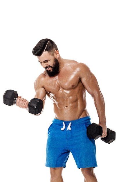 Athletic muscular man doing exercises with dumbbells. Strong bodybuilder with naked torso on white background