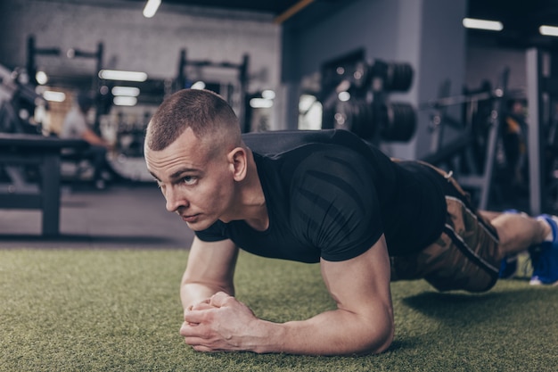 Uomo muscolare atletico che si esercita in palestra