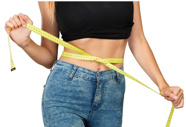 Athletic slim woman measuring her waist by measure tape 