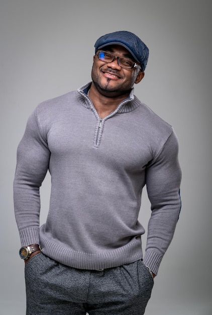 Athletic smilling fashionable model posing in studio Muscular man in shirt smilling into camera