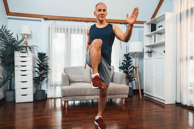 Foto l'uomo anziano atletico e sportivo fa posa in esecuzione a casa stile di vita sano e in forma del corpo come concetto di esercizio di allenamento a casa dopo il pensionamento peso