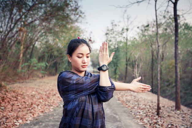 Photo athletic woman asia warming up and young female athlete exercising and stretching in a park before r