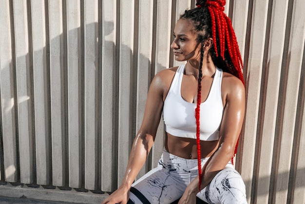 Athletic woman Closeup portrait sitting on med ball Strength and motivationPhoto of sporty woman in fashionable sportswear