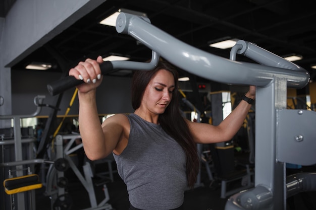 Athletic woman doing pullups at sports studio